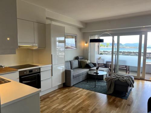 cocina y sala de estar con sofá y mesa en Seaside Central Apartment, en Osøyro