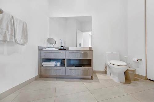a white bathroom with a toilet and a sink at Picturesque Beachfront Condo #4105 - LOVELY 2BD and 2BA PENTHOUSE WITH DIRECT OCEAN VIEW in Hollywood