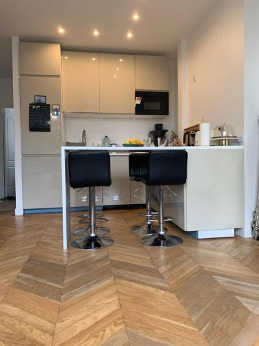 a kitchen with a counter and two bar stools at Nice stay in city center with Parking in Boulogne-Billancourt