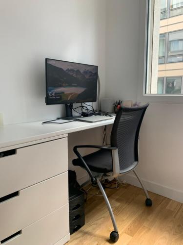 a white desk with a computer monitor and a chair at Nice stay in city center with Parking in Boulogne-Billancourt