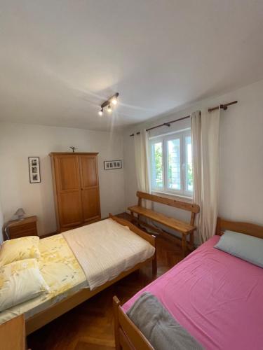 a bedroom with two beds and a window at Villa Joković in Lumbarda