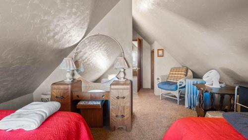 a bedroom with a bed and a mirror and a chair at Cozy house close to Main St in downtown Leadville! in Leadville