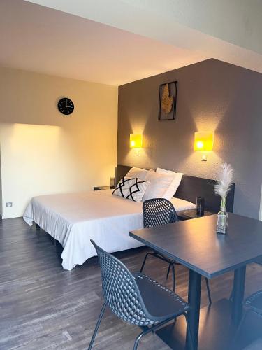 une chambre d'hôtel avec un lit, une table et des chaises dans l'établissement Studio entre terre et mer - 4 personnes, à Arles
