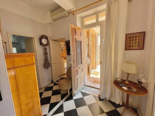 une chambre avec une porte, une table et une horloge dans l'établissement Villa Chateaubriand sur Hyères proche du centre, à Hyères