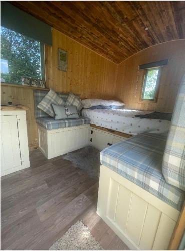 um quarto com 2 camas num chalé de madeira em Cosycoopmiskineggs em Llantrisant