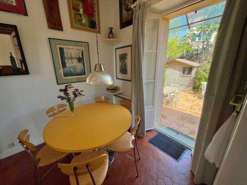une salle à manger avec une table et des chaises et une fenêtre dans l'établissement Villa Chateaubriand sur Hyères proche du centre, à Hyères