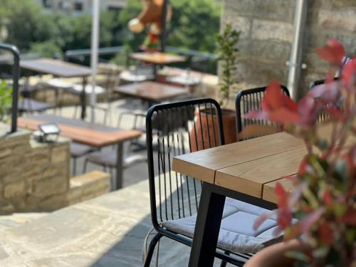 due sedie e un tavolo di legno e tavoli con tavoli e panche di The Stone Sky Hotel a Gjirokastër