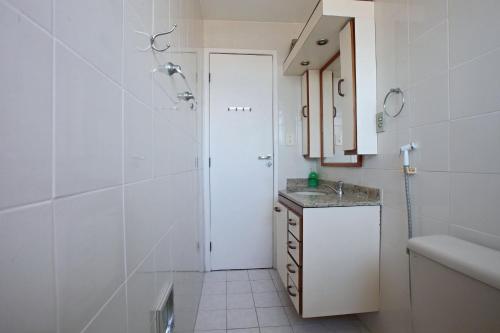 un bagno bianco con doccia e lavandino di Amplo Apartamento com Suítes e Ar Refrigerado a 400 metros da Praia do Forte a Cabo Frio