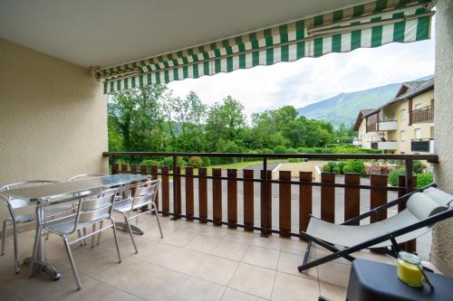 balkon ze stołami i krzesłami oraz dużym oknem w obiekcie Lac et montagnes charmant appartement au calme pour 4 personnes w mieście Saint-Jorioz