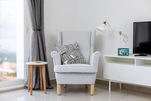 a living room with a chair and a television at The Gallery Luxury Apartments in Accra