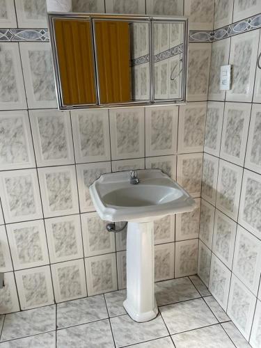 a bathroom with a white sink and a mirror at POUSADA PARLATORIUM in Tiradentes