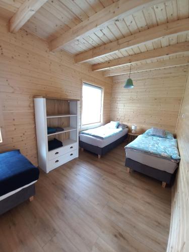 a room with two beds in a wooden room at Domki Sunset Lubiatowo in Lubiatowo