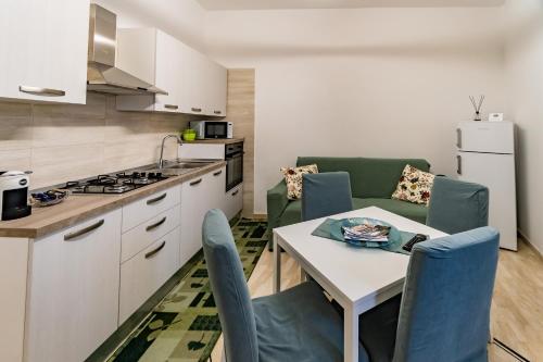 a kitchen and living room with a table and chairs at Appartamenti Petali Di Rosa in Custonaci