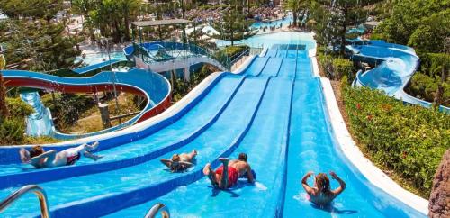 a pool at a theme park with people riding a water slide at Luxury Suites Fuengirola in Fuengirola