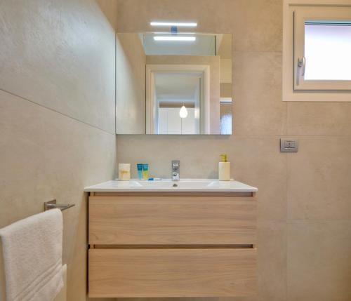 La salle de bains est pourvue d'un lavabo et d'un miroir. dans l'établissement Appartamento Pigno, à Bardolino