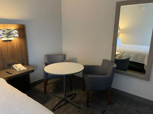 a room with a table and two chairs and a mirror at Holiday Inn Express Mexico City Satelite by IHG in Mexico City