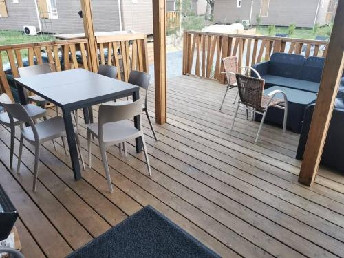a patio with a table and chairs on a deck at Chez Christian Chalet aux bords du lac de Peyre in Labouheyre