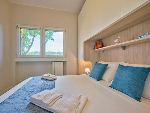 una camera da letto con un grande letto bianco con cuscini blu di Appartamento Pigno a Bardolino