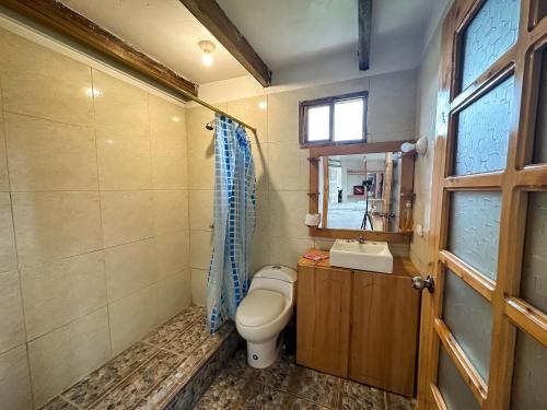 baño con aseo y lavabo y ventana en Ilinizas Mountain Lodge, en Chaupi