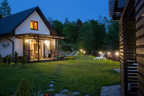 una casa con un patio iluminado por la noche en Domki i tyle, en Rabka