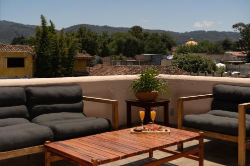 un patio con 2 sofás y una mesa con gafas. en Casa del Alma Hotel Boutique & Spa, en San Cristóbal de Las Casas