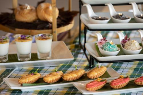 a table topped with plates of pastries and drinks at Pimali Resort & Training Centre in Nong Khai