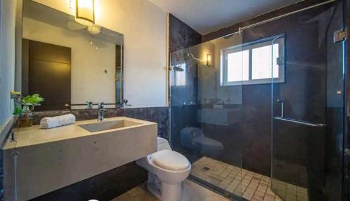 a bathroom with a toilet and a sink and a shower at Casa Jocelyne Alberca Privada in Puerto Vallarta
