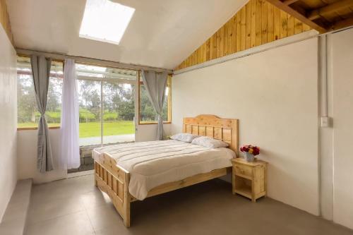 a bedroom with a bed and a window at Ilinizas Mountain Lodge in Chaupi