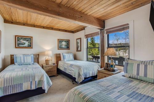 a bedroom with two beds and a window at Interlude Condominiums 2-Bedroom Unit 209 in Snowmass Village