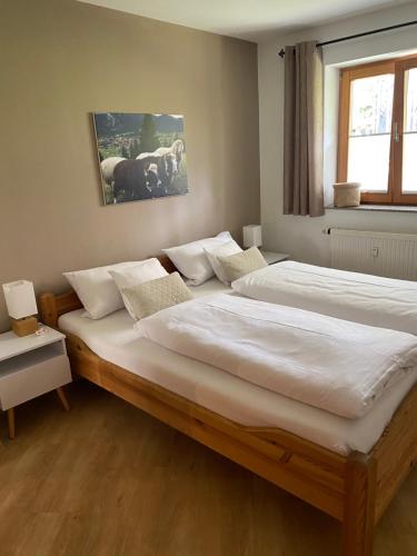 - une chambre avec 2 lits et des draps blancs dans l'établissement Ferienwohnung Martina Bauer, à Oberammergau
