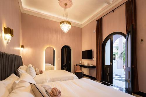 um quarto de hotel com duas camas e um lustre em HOLT's Casa De Mi Independencia em Oaxaca de Juárez