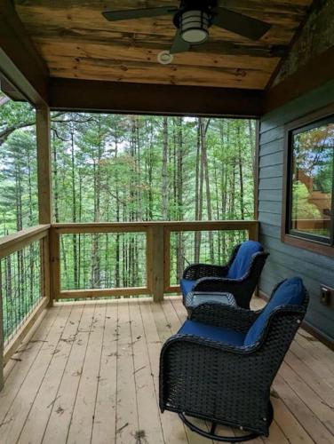 2 sillas en un porche cubierto con árboles en Oak Treehouse Cabin Rustic Luxury Near Asheville, en Marshall