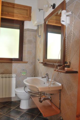 y baño con lavabo, aseo y espejo. en Agriturismo Roseto, en Serra San Bruno