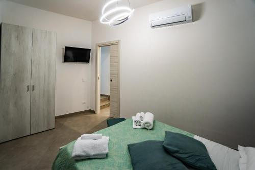 una camera da letto con un letto e due asciugamani di Appartamenti Petali Di Rosa a Custonaci