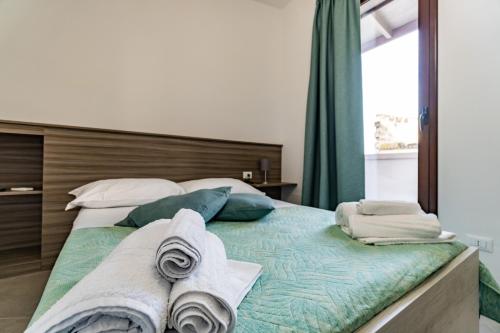 a bedroom with a bed with towels on it at Appartamenti Petali Di Rosa in Custonaci