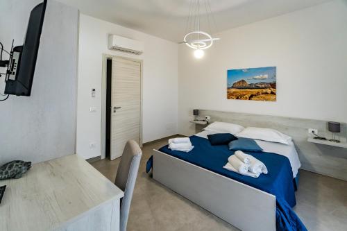 a bedroom with a bed and a table and a desk at Appartamenti Petali Di Rosa in Custonaci