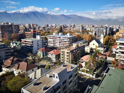 an aerial view of a city with mountains in the background at Hotel Nodo - El hotel que respira in Santiago