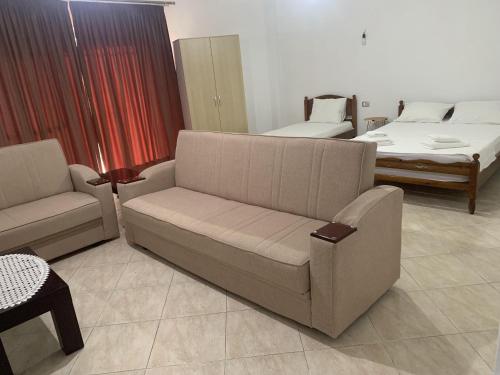 a living room with a couch and a chair and a bed at Vila HALIM BANI in Sarandë
