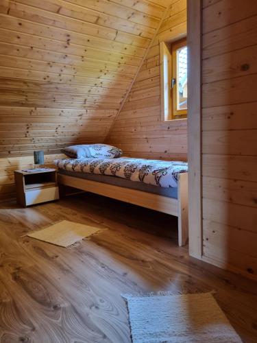 Cette chambre comprend un lit dans une cabane en bois. dans l'établissement Blask Jeziora, à Frydman