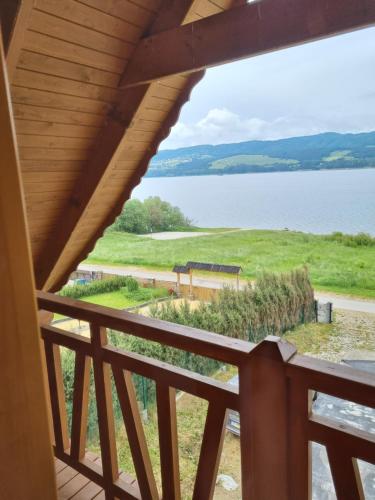 Una vista del agua desde el balcón de una casa. en Blask Jeziora, en Frydman