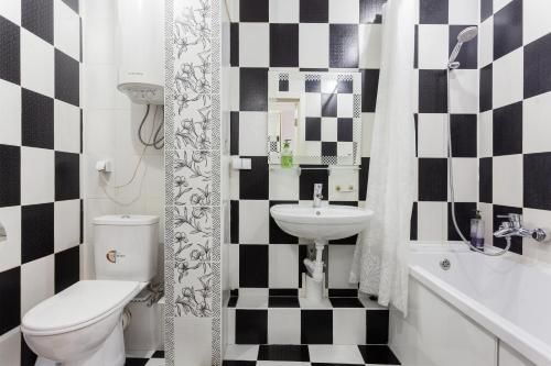 a black and white bathroom with a sink and a toilet at Apartments on Polytech in Kyiv