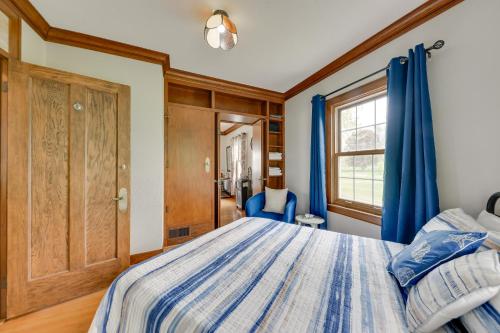 a bedroom with a blue bed and a window at Pistakee Lake Estate with Boat Dock and Hot Tub! in Johnsburg