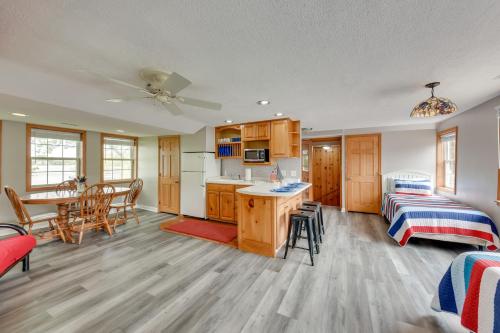 a kitchen and a living room with a bed and a couch at Pistakee Lake Estate with Boat Dock and Hot Tub! in Johnsburg