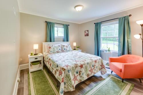 a bedroom with a bed and a orange chair at Pistakee Lake Estate with Boat Dock and Hot Tub! in Johnsburg