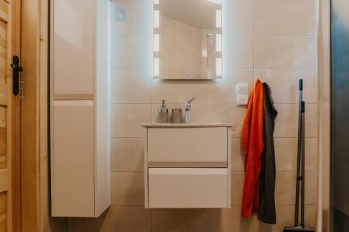 a white bathroom with a sink and a counter at Domki Sunset Lubiatowo in Lubiatowo