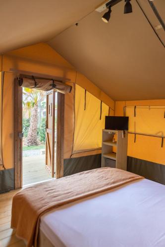 a bedroom with a bed in a tent at Camping Del Mar in Malgrat de Mar