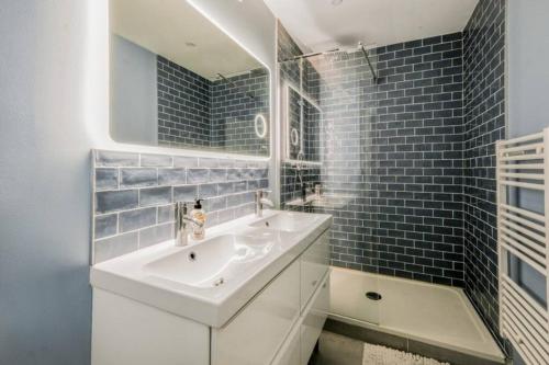 une salle de bain blanche avec un lavabo et un miroir dans l'établissement Le Minimes : vue de rêve au coeur de Toulouse, à Toulouse