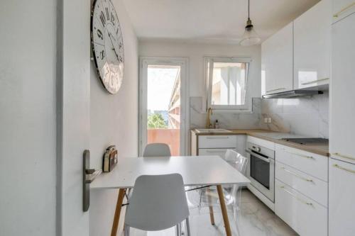 une cuisine avec une table et des chaises et une horloge au mur dans l'établissement Le Minimes : vue de rêve au coeur de Toulouse, à Toulouse