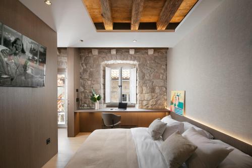 a bedroom with a large bed and a stone wall at Villa Lapisa in Dubrovnik