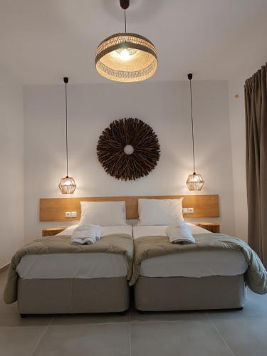 a bedroom with a large bed with a chandelier at Pel Mar in Pefkochori